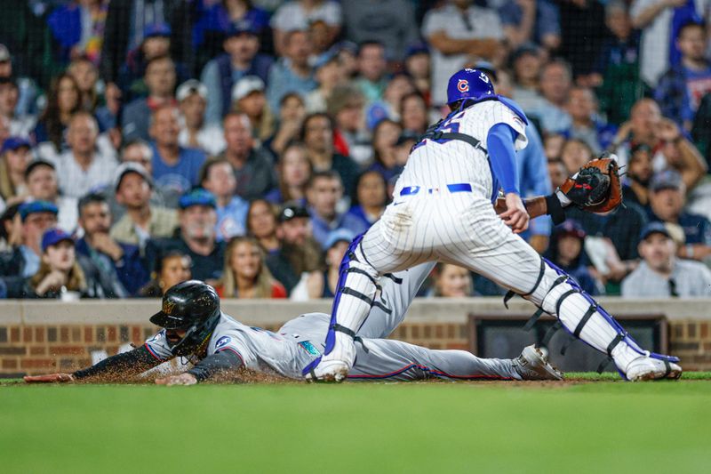 May 13, 2025; Chicago, Illinois, USA; Miami Marlins center fielder Derek Hill (3) scores against Chicago Cubs catcher Carson Kelly (15) during the seventh inning at Wrigley Field. Mandatory Credit: Kamil Krzaczynski-Imagn Images