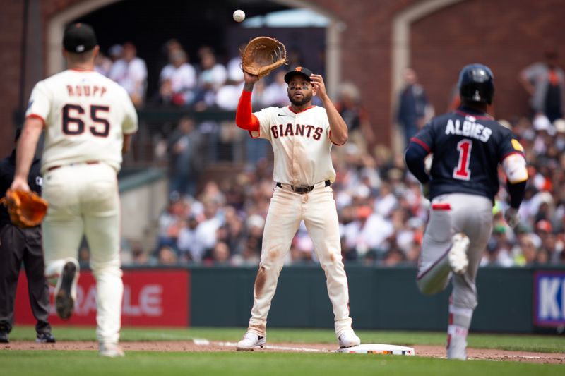 Jun 8, 2025; San Francisco, California, USA; San Francisco Giants first baseman Dominic Smith (7) takes the throw from starting pitcher Landen Roupp (65) in time to retire Atlanta Braves second baseman Ozzie Albies (1) during the sixth inning at Oracle Park. Mandatory Credit: D. Ross Cameron-Imagn Images