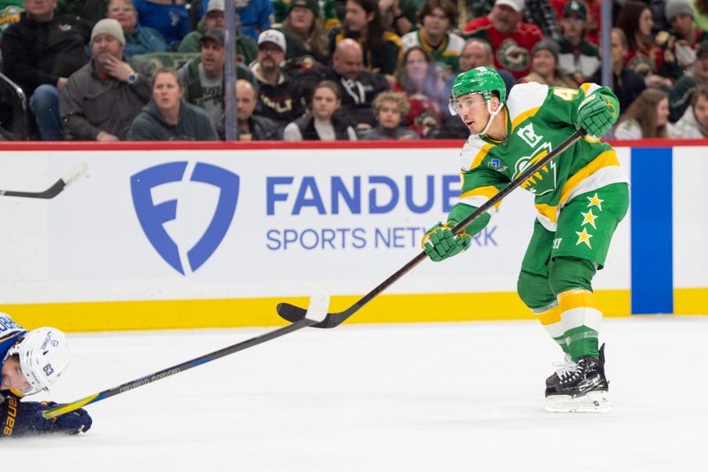 Mar 15, 2025; Saint Paul, Minnesota, USA; Minnesota Wild defenseman Jared Spurgeon (46) shoots while blocked by St. Louis Blues left wing Jake Neighbours (63) in the second period at Xcel Energy Center. Mandatory Credit: Matt Blewett-Imagn Images