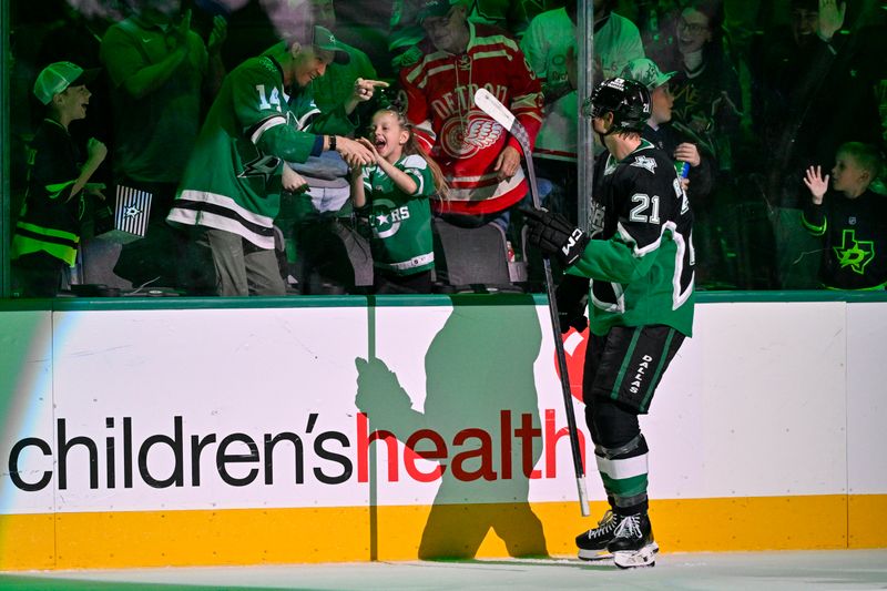 Feb 28, 2026; Dallas, Texas, USA; Dallas Stars left wing Jason Robertson (21) tosses a puck to a young fan after Robertson scores the game winning goal against the Nashville Predators during the overtime period at the American Airlines Center. Mandatory Credit: Jerome Miron-Imagn Images