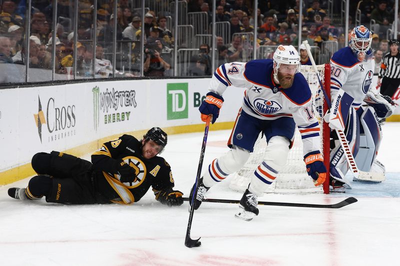 Dec 18, 2025; Boston, Massachusetts, USA; Edmonton Oilers defenseman Mattias Ekholm (14) skates the puck past fallen Boston Bruins right wing David Pastrnak (88) during the third period at TD Garden. Mandatory Credit: Winslow Townson-Imagn Images