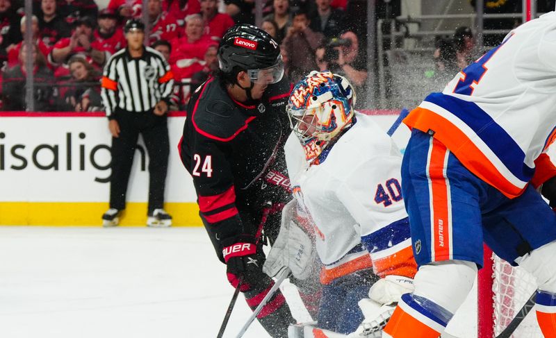 Apr 20, 2024; Raleigh, North Carolina, USA; Carolina Hurricanes center Seth Jarvis (24) collides into New York Islanders goaltender Semyon Varlamov (40) during the first period in game one of the first round of the 2024 Stanley Cup Playoffs at PNC Arena. Mandatory Credit: James Guillory-USA TODAY Sports