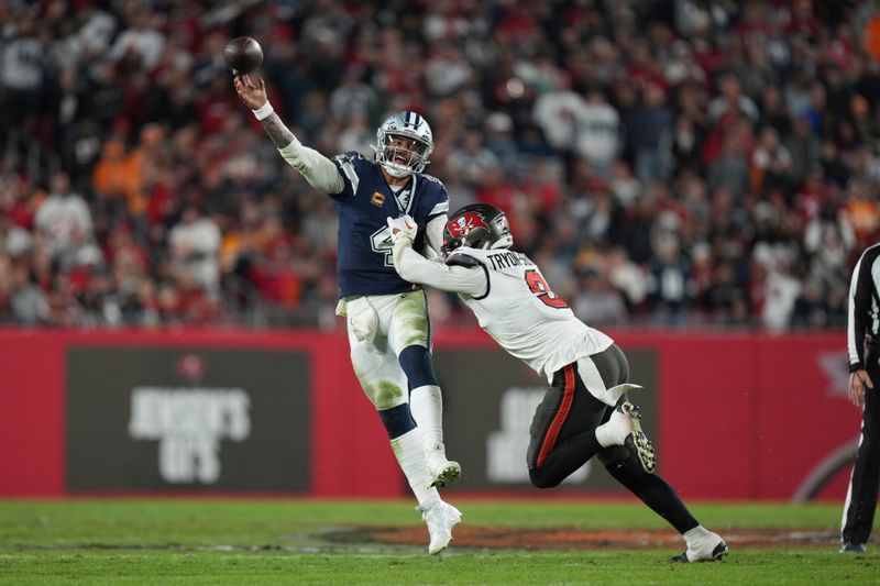 Dallas Cowboys quarterback Dak Prescott (4) makes a leaping pass as he is pressured by Tampa Bay Buccaneers linebacker Joe Tryon-Shoyinka (9) during an NFL wild-card football game, Monday, Jan. 16, 2023, in Tampa, Fla. (AP Photo/Peter Joneleit)