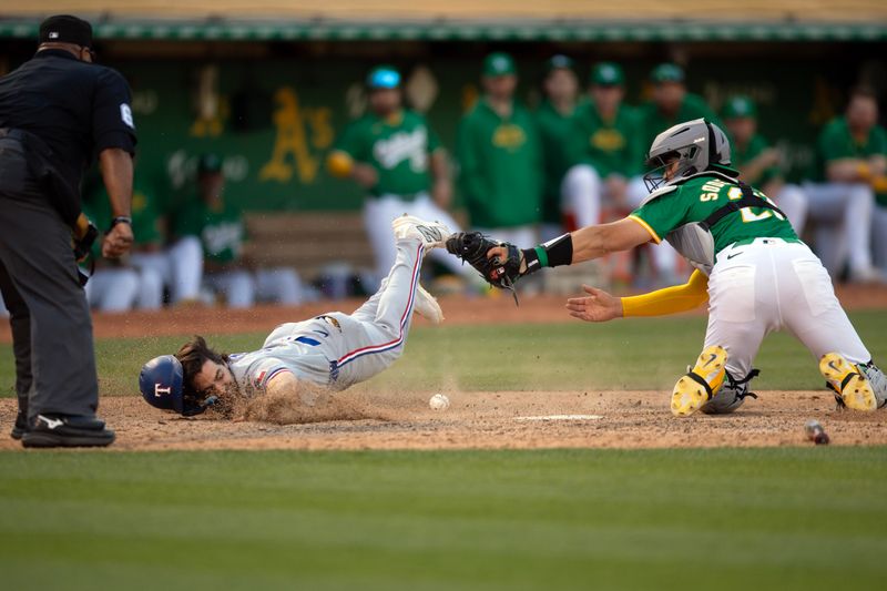 May 8, 2024; Oakland, California, USA; Texas Rangers shortstop Josh Smith (8) slides safely home past the tag attempt of Oakland Athletics catcher Tyler Soderstrom (21) during the eighth inning at Oakland-Alameda County Coliseum. Umpire is Laz Diaz. Mandatory Credit: D. Ross Cameron-USA TODAY Sports