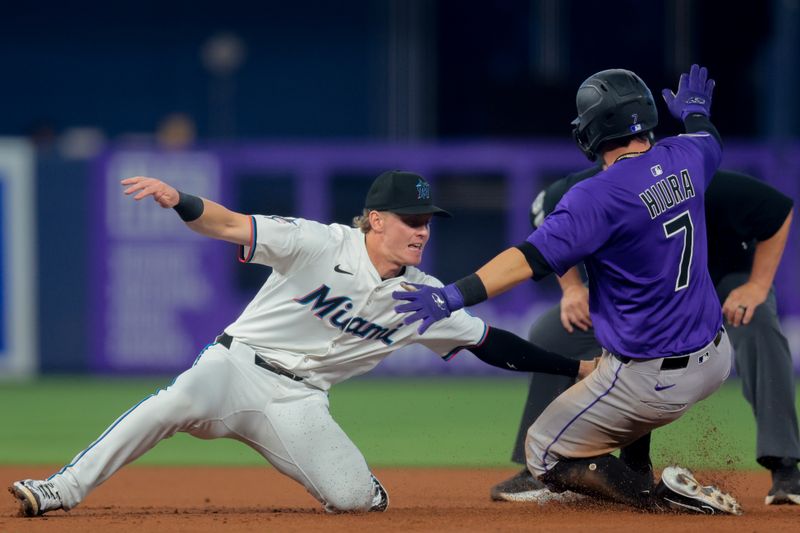 Jun 4, 2025; Miami, Florida, USA; Colorado Rockies first baseman Keston Hiura (7) reaches second base against Miami Marlins second baseman Jack Winkler (63) on a wild pitch by starting pitcher Cal Quantrill (not pictured) during the second inning at loanDepot Park. Mandatory Credit: Sam Navarro-Imagn Images