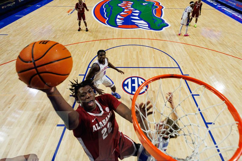 Feb 1, 2026; Gainesville, Florida, USA; Alabama Crimson Tide forward Aiden Sherrell (22) makes a layup over Florida Gators forward Thomas Haugh (10) during the first half at Exactech Arena at the Stephen C. O'Connell Center. Mandatory Credit: Matt Pendleton-Imagn Images