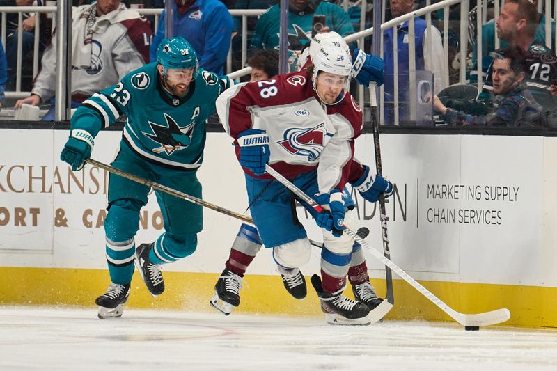 Oct 20, 2024; San Jose, California, USA; Colorado Avalanche left wing Miles Wood (28) controls the puck against San Jose Sharks right wing Barclay Goodrow (23) during the first period at SAP Center at San Jose. Mandatory Credit: Robert Edwards-Imagn Images