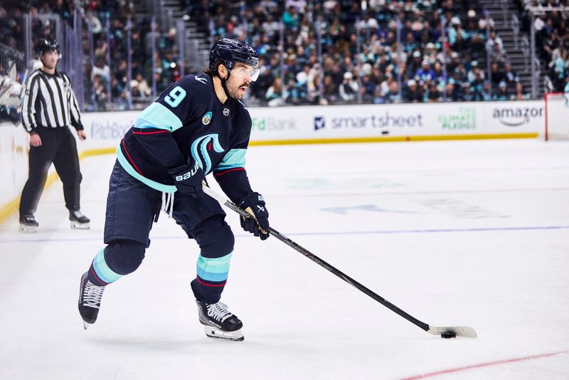 Dec 14, 2025; Seattle, Washington, USA;  Seattle Kraken center Chandler Stephenson (9) looks to pass during the second period against the Buffalo Sabres at Climate Pledge Arena. Mandatory Credit: Blake Dahlin-Imagn Images