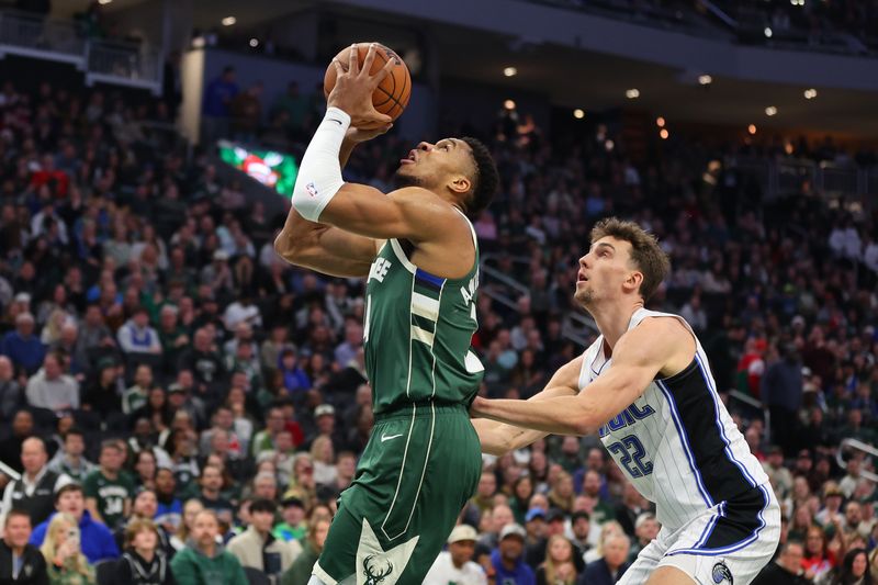 MILWAUKEE, WISCONSIN - DECEMBER 21: Giannis Antetokounmpo #34 of the Milwaukee Bucks is fouled by Franz Wagner #22 of the Orlando Magic during a game at Fiserv Forum on December 21, 2023 in Milwaukee, Wisconsin. NOTE TO USER: User expressly acknowledges and agrees that, by downloading and or using this photograph, User is consenting to the terms and conditions of the Getty Images License Agreement. (Photo by Stacy Revere/Getty Images)