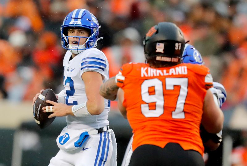 Nov 25, 2023; Stillwater, Oklahoma, USA;  BYU's Jake Retzlaff (12) drops back to throw a pass during the first half against the Oklahoma State University Cowboys at Boone Pickens Stadium. Mandatory Credit: Sarah Phipps-USA TODAY Sports