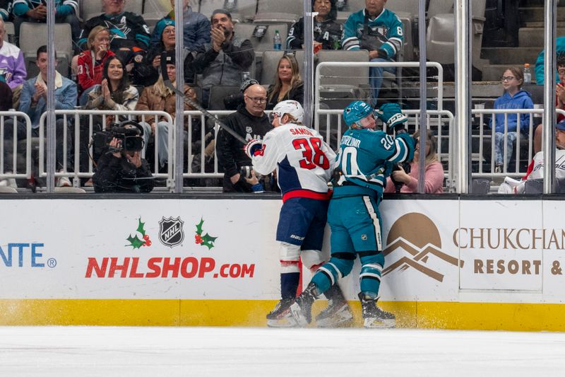 Nov 27, 2023; San Jose, California, USA; San Jose Sharks left wing Fabian Zetterlund (20) is checked into the boards by Washington Capitals defenseman Rasmus Sandin (38) during the first period at SAP Center at San Jose. Mandatory Credit: Neville E. Guard-USA TODAY Sports