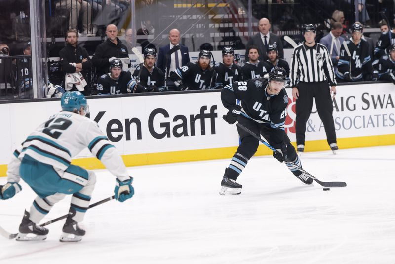 Oct 28, 2024; Salt Lake City, Utah, USA;  Utah Hockey Club defenseman Ian Cole (28) tries to shoot the puck past San Jose Sharks left wing William Eklund (72) during the second period at Delta Center. Mandatory Credit: Chris Nicoll-Imagn Images