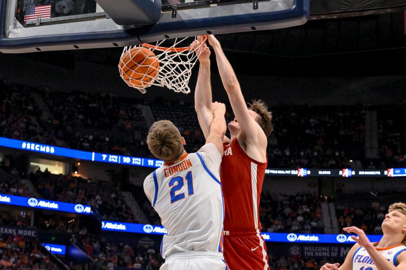 Mar 15, 2025; Nashville, TN, USA;  Alabama Crimson Tide forward Grant Nelson (4) dunks the ball over Florida Gators forward Alex Condon (21) during the first half at Bridgestone Arena. Mandatory Credit: Steve Roberts-Imagn Images