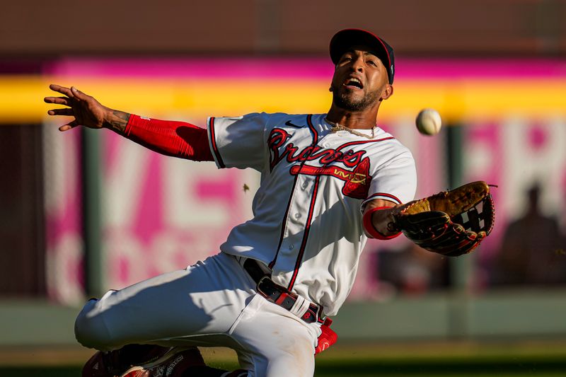 Oct 1, 2023; Cumberland, Georgia, USA; Atlanta Braves left fielder Eddie Rosario (8) makes a sliding catch on a ball hit by Washington Nationals shortstop CJ Abrams (5) (not shown) during the eighth inning at Truist Park. Mandatory Credit: Dale Zanine-USA TODAY Sports