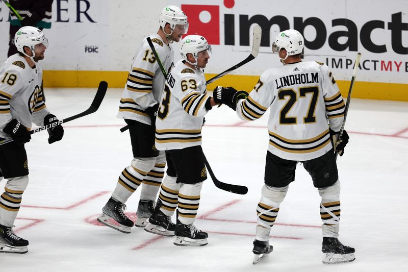 Oct 22, 2023; Anaheim, California, USA;  Boston Bruins left wing Brad Marchand (63) is congratulated by defenseman Hampus Lindholm (27) after scoring a goal during the third period against the Anaheim Ducks at Honda Center. Mandatory Credit: Kiyoshi Mio-USA TODAY Sports