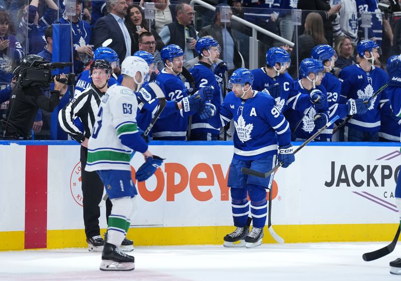 Jan 10, 2026; Toronto, Ontario, CAN; Toronto Maple Leafs center John Tavares (91) celebrates at the bench after scoring a goal against the Vancouver Canucks during the second period at Scotiabank Arena. Mandatory Credit: Nick Turchiaro-Imagn Images