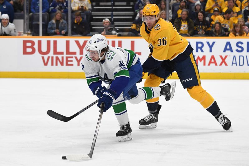 Dec 19, 2023; Nashville, Tennessee, USA; Vancouver Canucks defenseman Quinn Hughes (43) handles the puck against Nashville Predators left wing Cole Smith (36) during the first period at Bridgestone Arena. Mandatory Credit: Christopher Hanewinckel-USA TODAY Sports