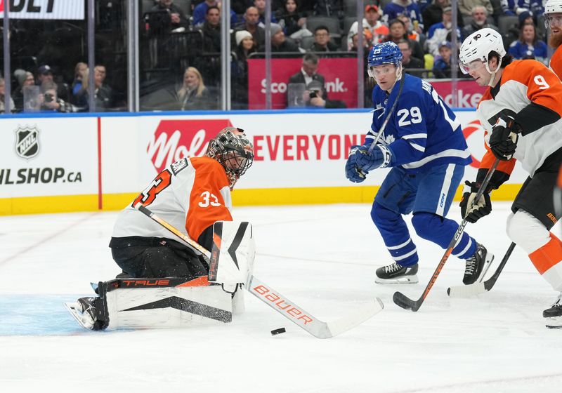 Feb 15, 2024; Toronto, Ontario, CAN; Philadelphia Flyers goaltender Samuel Ersson (33) handles the puck as defenseman Jamie Drysdale (9) battles with Toronto Maple Leafs right wing Pontus Holmberg (29) during the first period at Scotiabank Arena. Mandatory Credit: Nick Turchiaro-USA TODAY Sports