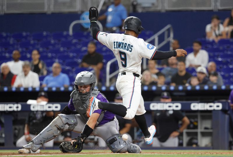 Jun 2, 2025; Miami, Florida, USA;  Miami Marlins shortstop Xavier Edwards (9) scores against Colorado Rockies catcher Hunter Goodman (15) during the first inning at loanDepot Park. Mandatory Credit: Rhona Wise-Imagn Images