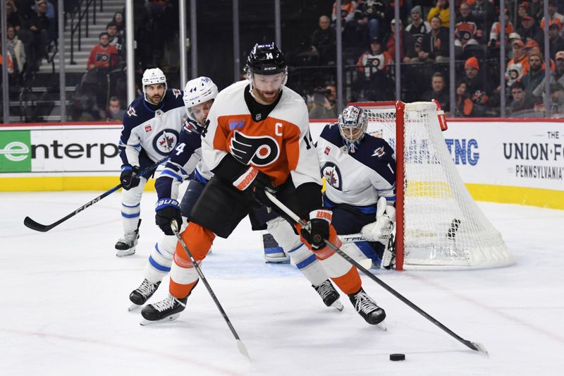 Mar 6, 2025; Philadelphia, Pennsylvania, USA; Philadelphia Flyers center Sean Couturier (14) is defended by Winnipeg Jets defenseman Josh Morrissey (44) during the third period at Wells Fargo Center. Mandatory Credit: Eric Hartline-Imagn Images