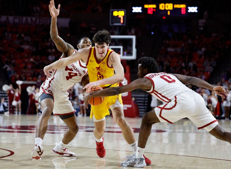 Jan 6, 2024; Norman, Oklahoma, USA; Iowa State Cyclones forward Milan Momcilovic (22) drives between Oklahoma Sooners forward Jalon Moore (14) and guard Le'Tre Darthard (0) during the first half at Lloyd Noble Center. Mandatory Credit: Alonzo Adams-USA TODAY Sports