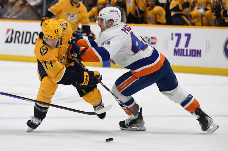 Jan 13, 2024; Nashville, Tennessee, USA; Nashville Predators right wing Luke Evangelista (77) is hit by New York Islanders center Jean-Gabriel Pageau (44) as he enters the offensive zone during the first period at Bridgestone Arena. Mandatory Credit: Christopher Hanewinckel-USA TODAY Sports