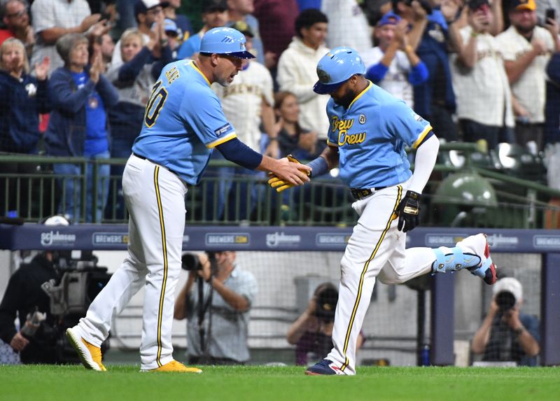 Sep 15, 2023; Milwaukee, Wisconsin, USA; Milwaukee Brewers third base coach Jason Lane (40) congratulates   Milwaukee Brewers first baseman Carlos Santana (41) after hitting a home run against the Washington Nationals in the fifth inning at American Family Field. Mandatory Credit: Michael McLoone-USA TODAY Sports