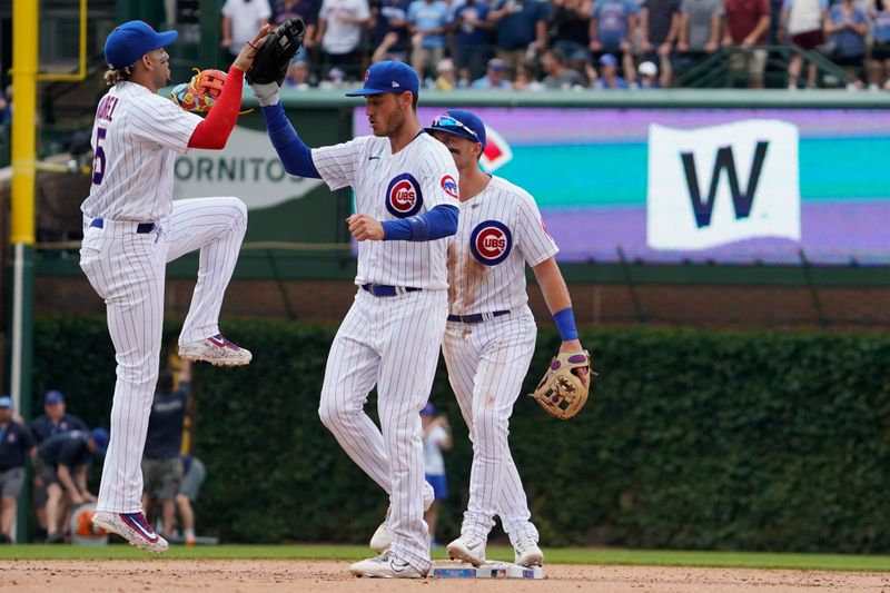 Jul 15, 2023; Chicago, Illinois, USA; Chicago Cubs center fielder Cody Bellinger (24) and second baseman Christopher Morel (5) celebrate their win against the Boston Red Sox at Wrigley Field. Mandatory Credit: David Banks-USA TODAY Sports