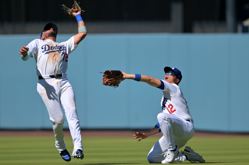 Aug 31, 2025; Los Angeles, California, USA;  Los Angeles Dodgers second baseman Miguel Rojas (72) avoids a collision with left fielder Alex Call (12) on a pop up by Arizona Diamondbacks second baseman Ildemaro Vargas (6) during the eighth inning at Dodger Stadium. Mandatory Credit: Jayne Kamin-Oncea-Imagn Images