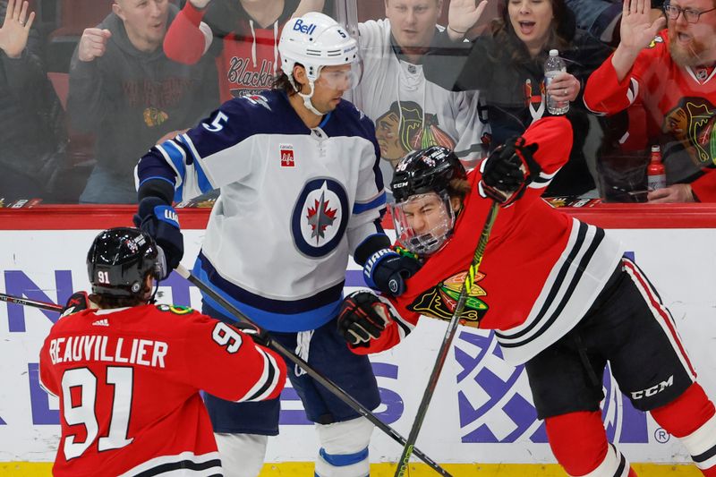 Feb 23, 2024; Chicago, Illinois, USA; Winnipeg Jets defenseman Brenden Dillon (5) pushes Chicago Blackhawks center Connor Bedard (98) during the third period at United Center. Mandatory Credit: Kamil Krzaczynski-USA TODAY Sports