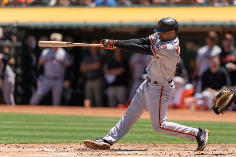 Aug 6, 2023; Oakland, California, USA;  San Francisco Giants first baseman LaMonte Wade Jr. (31) hits an RBI single during the second inning against the Oakland Athletics at Oakland-Alameda County Coliseum. Mandatory Credit: Stan Szeto-USA TODAY Sports