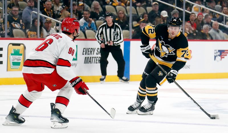 Oct 18, 2024; Pittsburgh, Pennsylvania, USA;  Pittsburgh Penguins left wing Anthony Beauvillier (72) carries the puck into the offensive zone as Carolina Hurricanes center Jack Roslovic (96) defends during the first period at PPG Paints Arena. Mandatory Credit: Charles LeClaire-Imagn Images