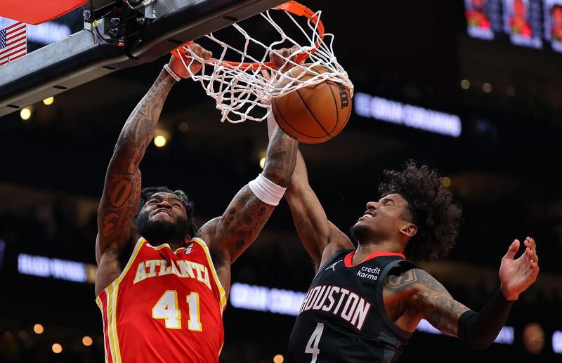 ATLANTA, GEORGIA - FEBRUARY 10:  Saddiq Bey #41 of the Atlanta Hawks dunks against Jalen Green #4 of the Houston Rockets during the first quarter at State Farm Arena on February 10, 2024 in Atlanta, Georgia.  NOTE TO USER: User expressly acknowledges and agrees that, by downloading and/or using this photograph, user is consenting to the terms and conditions of the Getty Images License Agreement.  (Photo by Kevin C. Cox/Getty Images)