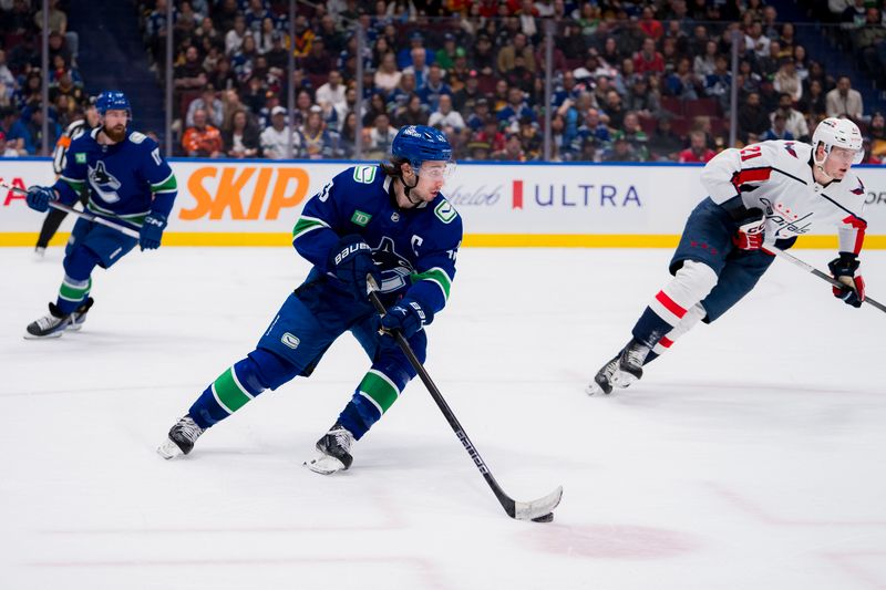 Mar 16, 2024; Vancouver, British Columbia, CAN; Vancouver Canucks defenseman Quinn Hughes (43) handles the puck against the Washington Capitals in the second period at Rogers Arena. Mandatory Credit: Bob Frid-USA TODAY Sports