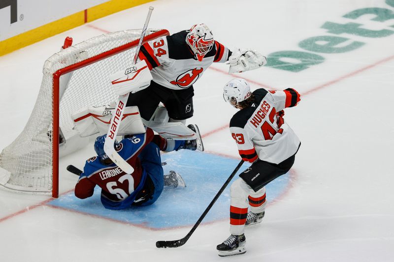 Feb 26, 2025; Denver, Colorado, USA; Colorado Avalanche left wing Artturi Lehkonen (62) slides into New Jersey Devils goaltender Jake Allen (34) as defenseman Luke Hughes (43) defends in the third period at Ball Arena. Mandatory Credit: Isaiah J. Downing-Imagn Images