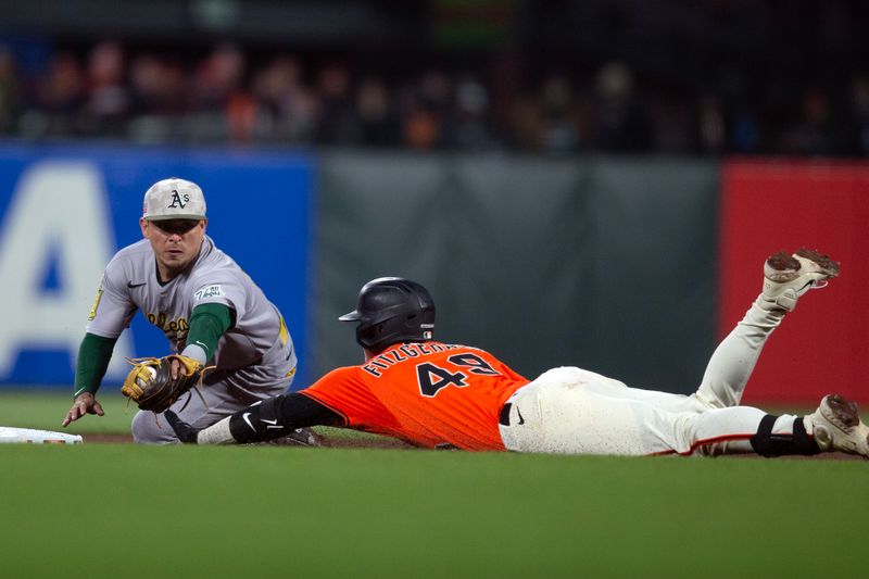 May 16, 2025; San Francisco, California, USA; San Francisco Giants second baseman Tyler Fitzgerald (49) slides safely into second with a double ahead of the tag by Athletics second baseman Luis Urías (17) during the fourth inning at Oracle Park. Mandatory Credit: D. Ross Cameron-Imagn Images