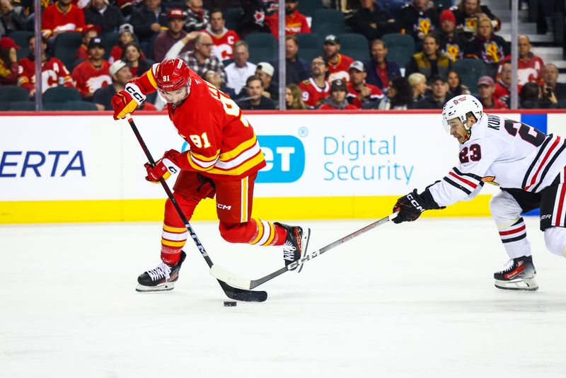 Oct 15, 2024; Calgary, Alberta, CAN; Calgary Flames center Nazem Kadri (91) controls the puck against Chicago Blackhawks center Philipp Kurashev (23) during the second period at Scotiabank Saddledome. Mandatory Credit: Sergei Belski-Imagn Images