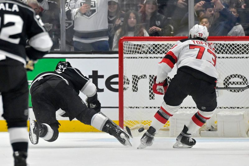 Mar 3, 2024; Los Angeles, California, USA; Los Angeles Kings center Phillip Danault (24) scores a goal past New Jersey Devils right wing Tyler Toffoli (73) for a hat trick in the third period at Crypto.com Arena. Mandatory Credit: Jayne Kamin-Oncea-USA TODAY Sports