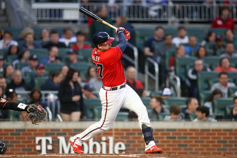 May 5, 2023; Atlanta, Georgia, USA; Atlanta Braves third baseman Austin Riley (27) hits a single against the Baltimore Orioles in the third inning at Truist Park. Mandatory Credit: Brett Davis-USA TODAY Sports