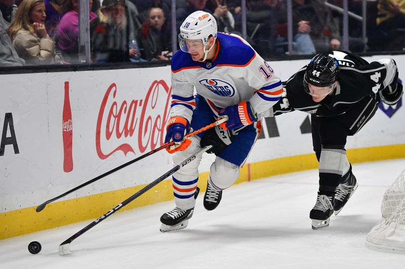 Dec 30, 2023; Los Angeles, California, USA; Los Angeles Kings defenseman Mikey Anderson (44) plays for the puck against Edmonton Oilers left wing Zach Hyman (18) during the first period at Crypto.com Arena. Mandatory Credit: Gary A. Vasquez-USA TODAY Sports