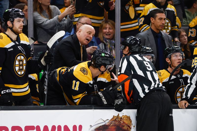 Oct 14, 2024; Boston, Massachusetts, USA; Boston Bruins head coach Jim Montogemry talks to referee Dan O'Rourke (9) during the first period of their game against the Florida Panthers at TD Garden. Mandatory Credit: Winslow Townson-Imagn Images