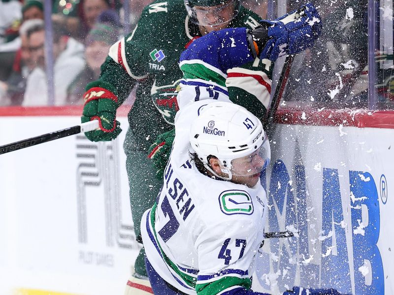 Dec 3, 2024; Saint Paul, Minnesota, USA; Minnesota Wild center Joel Eriksson Ek (14) checks Vancouver Canucks defenseman Noah Juulsen (47) during the third period at Xcel Energy Center. Mandatory Credit: Matt Krohn-Imagn Images