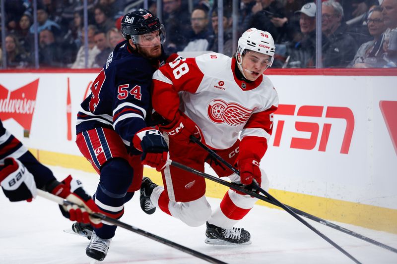 Jan 24, 2026; Winnipeg, Manitoba, CAN; Detroit Red Wings forward Emmitt Finnie (58) tries to skate away from Winnipeg Jets defenseman Dylan Samberg (54) during the first period at Canada Life Centre. Mandatory Credit: Terrence Lee-Imagn Images