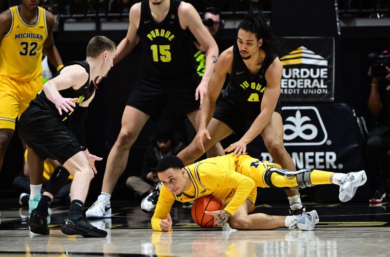 Jan 23, 2024; West Lafayette, Indiana, USA; Michigan Wolverines guard Jaelin Llewellyn (3) dives for a loose ball in front of Purdue Boilermakers forward Trey Kaufman-Renn (4) during the second half at Mackey Arena. Mandatory Credit: Marc Lebryk-USA TODAY Sports