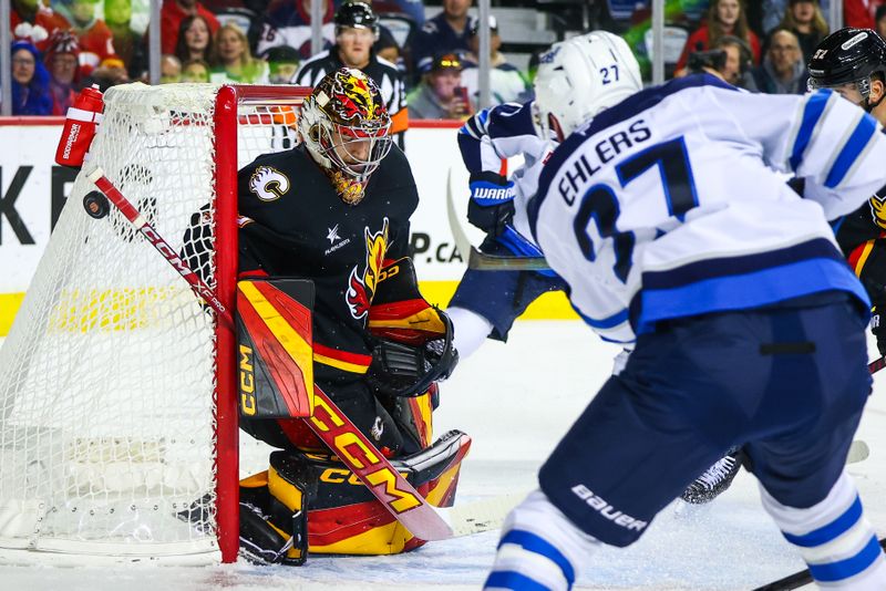 Oct 26, 2024; Calgary, Alberta, CAN; Calgary Flames goaltender Dustin Wolf (32) makes a save against Winnipeg Jets left wing Nikolaj Ehlers (27) during the first period at Scotiabank Saddledome. Mandatory Credit: Sergei Belski-Imagn Images