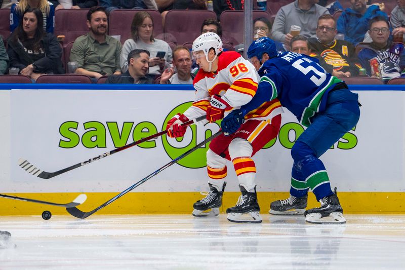 Oct 9, 2024; Vancouver, British Columbia, CAN; Vancouver Canucks defenseman Tyler Myers (57) stick checks Calgary Flames forward Andrei Kuzmenko (96) during the second period at Rogers Arena. Mandatory Credit: Bob Frid-Imagn Images