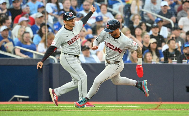 Jun 14, 2024; Toronto, Ontario, CAN;  Cleveland Indians shortstop Brayan Rocchio (4) is waved home by third base coach Rouglas Odor (53) to score against the Toronto Blue Jays in the fifth inning at Rogers Centre. Mandatory Credit: Dan Hamilton-USA TODAY Sports