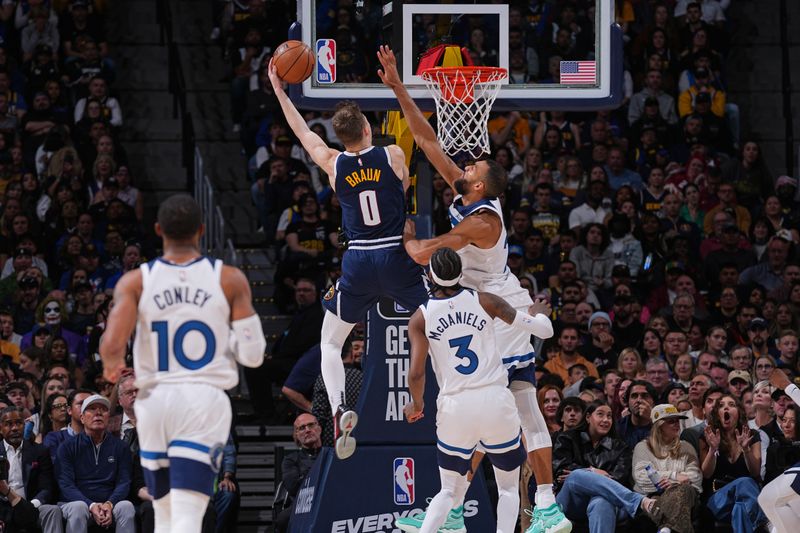 DENVER, CO - APRIL 10: Christian Braun #0 of the Denver Nuggets dunks the ball on Rudy Gobert #27 of the Minnesota Timberwolves on April 10, 2024 at the Ball Arena in Denver, Colorado. NOTE TO USER: User expressly acknowledges and agrees that, by downloading and/or using this Photograph, user is consenting to the terms and conditions of the Getty Images License Agreement. Mandatory Copyright Notice: Copyright 2024 NBAE (Photo by Bart Young/NBAE via Getty Images)