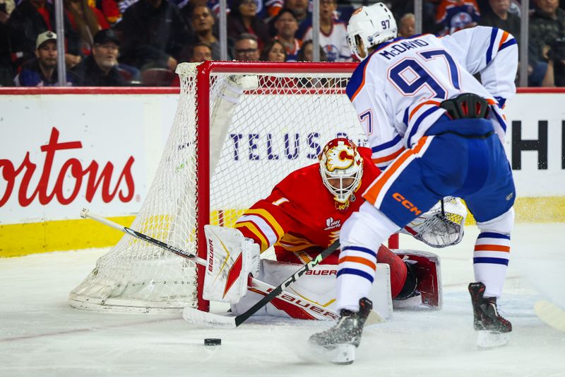 Feb 4, 2026; Calgary, Alberta, CAN; Calgary Flames goaltender Devin Cooley (1) makes a save against Edmonton Oilers center Connor McDavid (97) during the first period at Scotiabank Saddledome. Mandatory Credit: Sergei Belski-Imagn Images