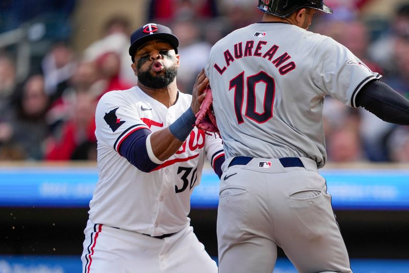 Apr 4, 2024; Minneapolis, Minnesota, USA; Minnesota Twins first baseman Carlos Santana (30) tags out Cleveland Guardians right fielder Ramon Laureano (10) during the sixth inning at Target Field. Mandatory Credit: Jordan Johnson-USA TODAY Sports